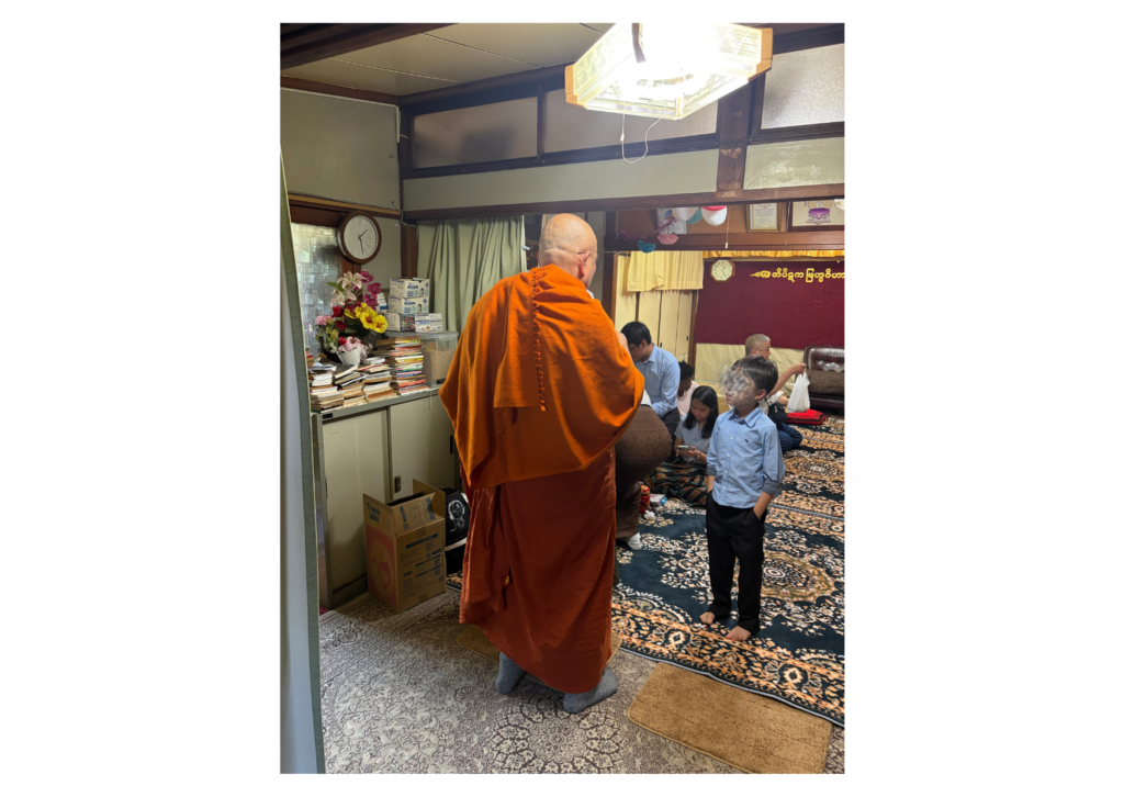 オレンジ色の袈裟をまとったお坊さんと子ども