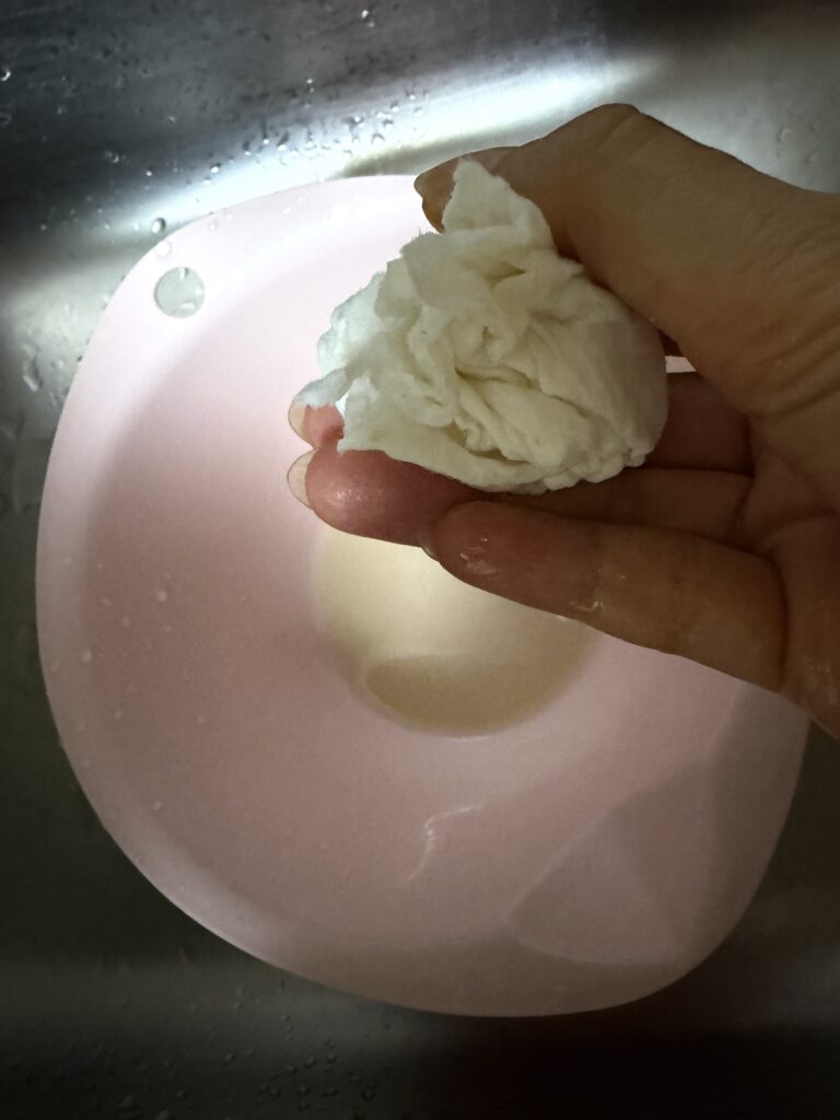 水を吸った紙をしぼっているところ